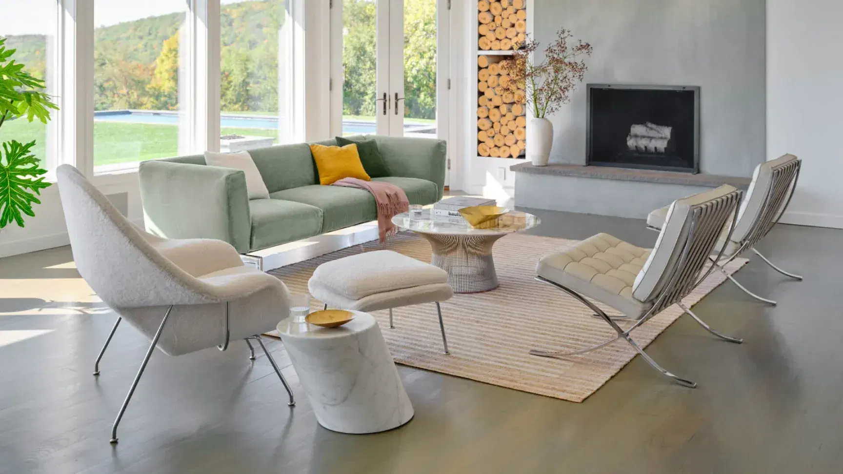 Modern living room featuring a Sohnne Womb Chair with Ottoman Replica and two Barcelona Chair Replicas